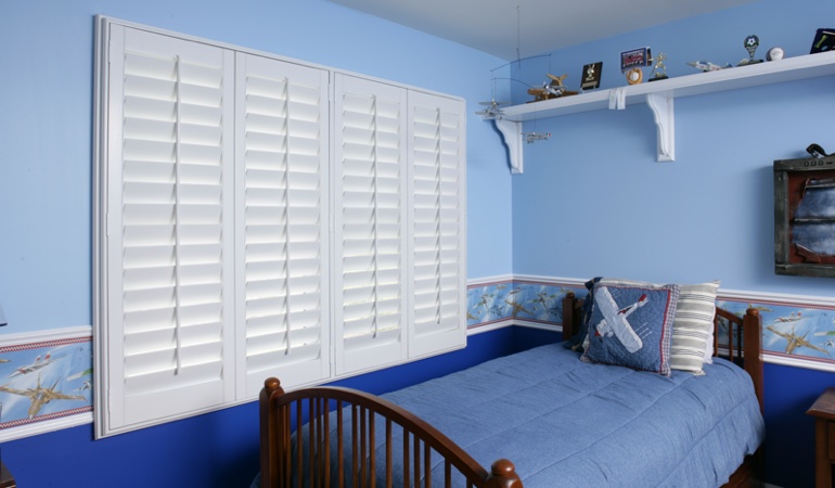 Blue kids bedroom with white plantation shutters in Jacksonville 